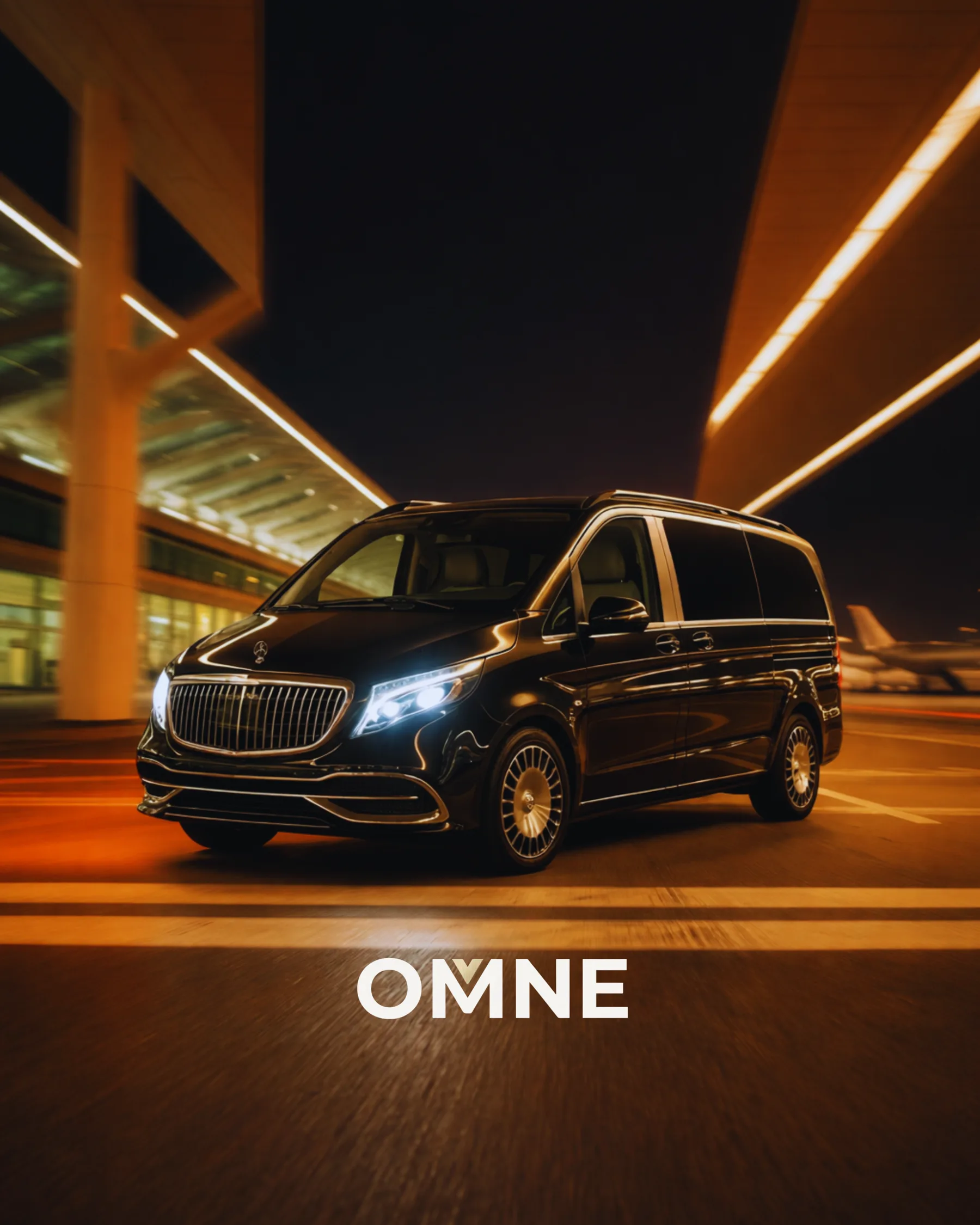 A black Mercedes-Maybach waiting outside an airport terminal at night